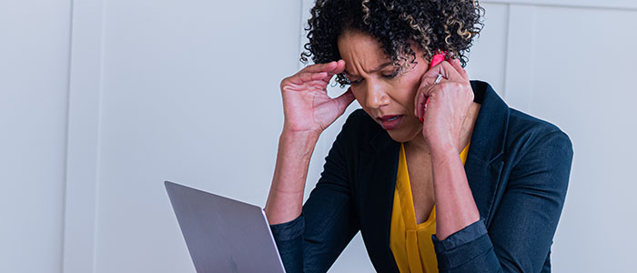 Frustrated woman on a mobile phone using a laptop