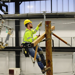 Apprentice lineman scaling a pole in the MidAmerican Training Center for Excellence