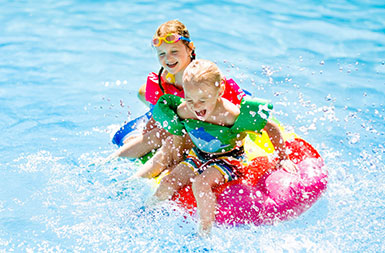 Boy and girl in a pool playing on rafts