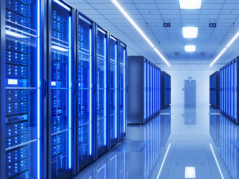 A row of servers lit with blue light inside of a datacenter
