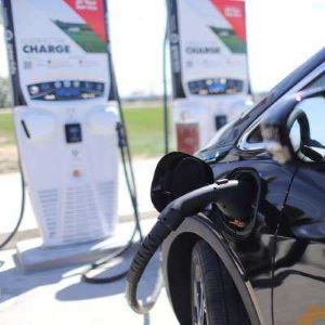 Black car plugged into EV fast chargers