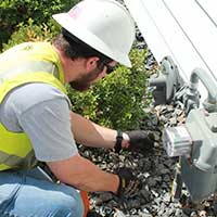 service man working on a residential gas meter