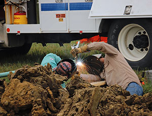 MidAmerican Employee working on a pipe that they are cutting