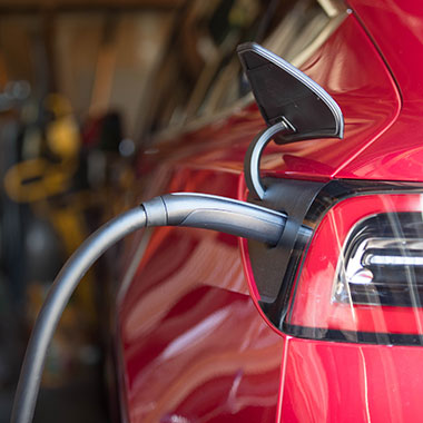 person charging car in a garage