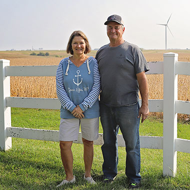 wind turbine land owners posing in front of a wind turbine