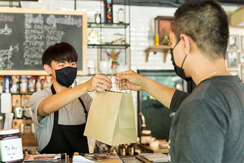 Small Business Employee Handing a Customer a Bag
