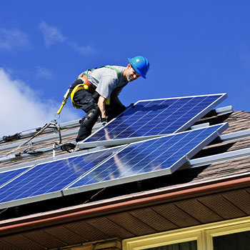 a person installing solar panels on a roof