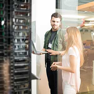 two people standing in front of a data base tower