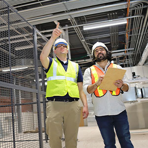 2 people inspecting furnace vents.