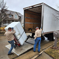 two MidAmerican contracted employees putting a refrigerator on a box truck