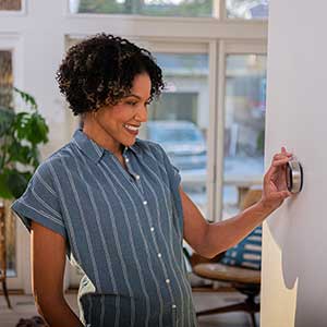 women working a smart thermostat