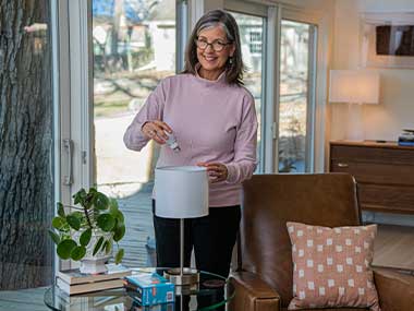 women changing a light bulb in a lamp