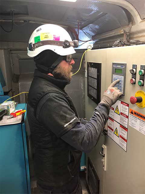 Jason Gruszeczka standing fixing a wind turbine