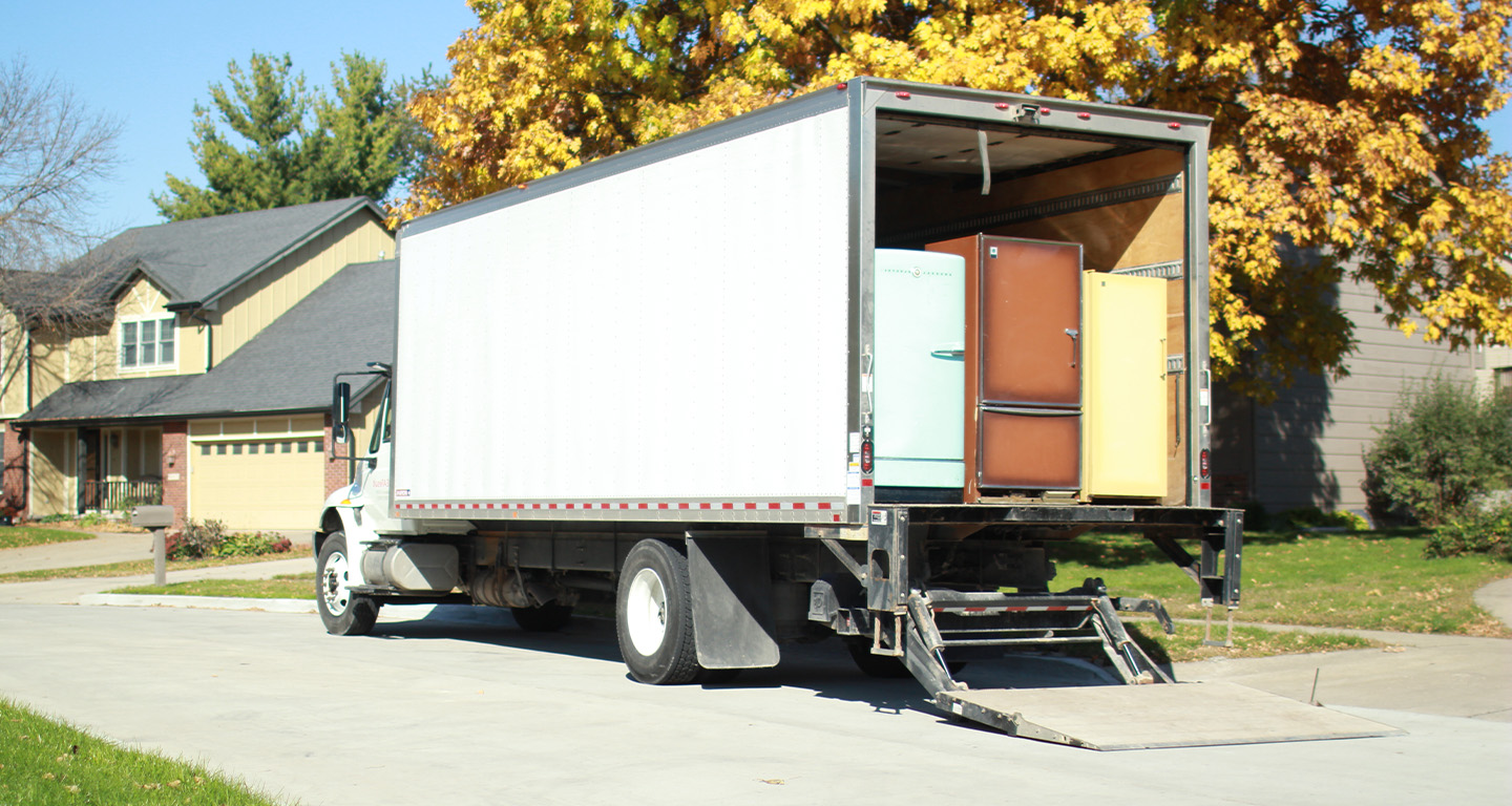 Moving truck with open rear door carrying refrigerators