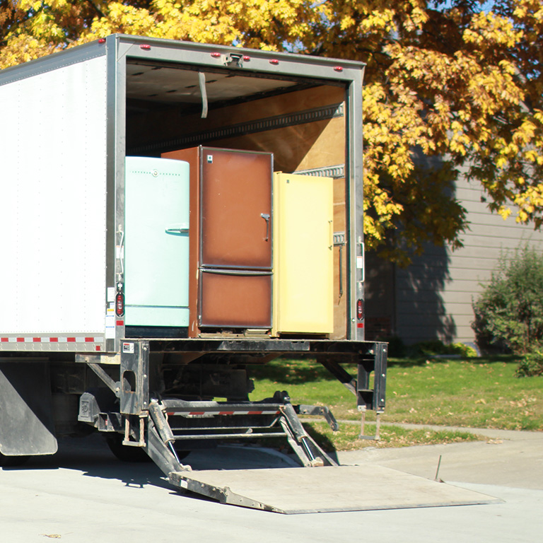Moving truck with open rear door carrying refrigerators