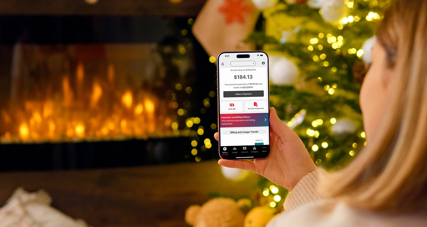 closeup of a hand holding a smartphone displaying the billing screen of the MidAmerican Energy app