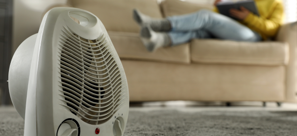 Close-up of a space heater sitting on the floor in a living room