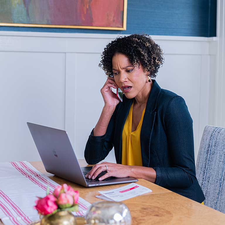 Black woman on phone looking alarmed