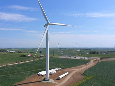 A wind turbine blade with three new blades set on the ground