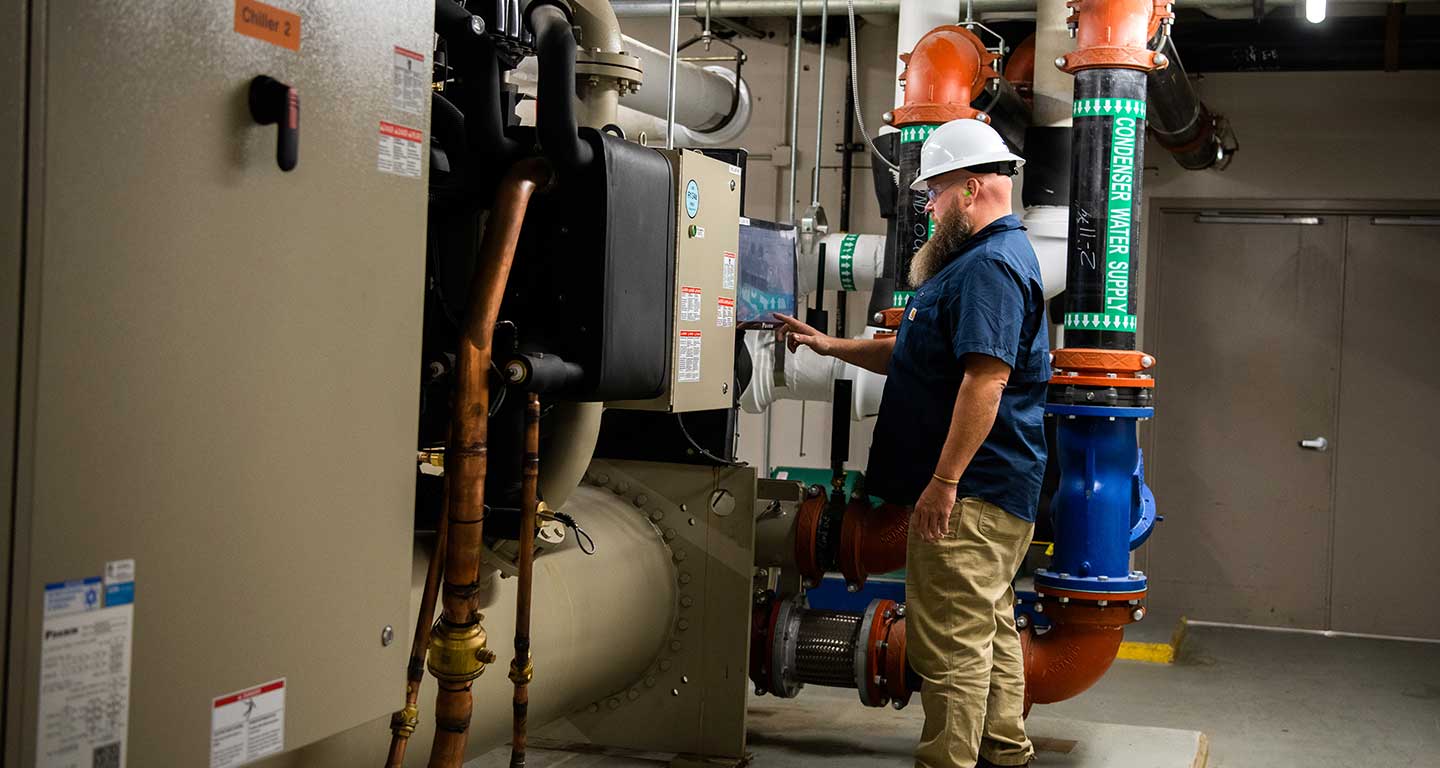 Facilities employee adjusts large HVAC system