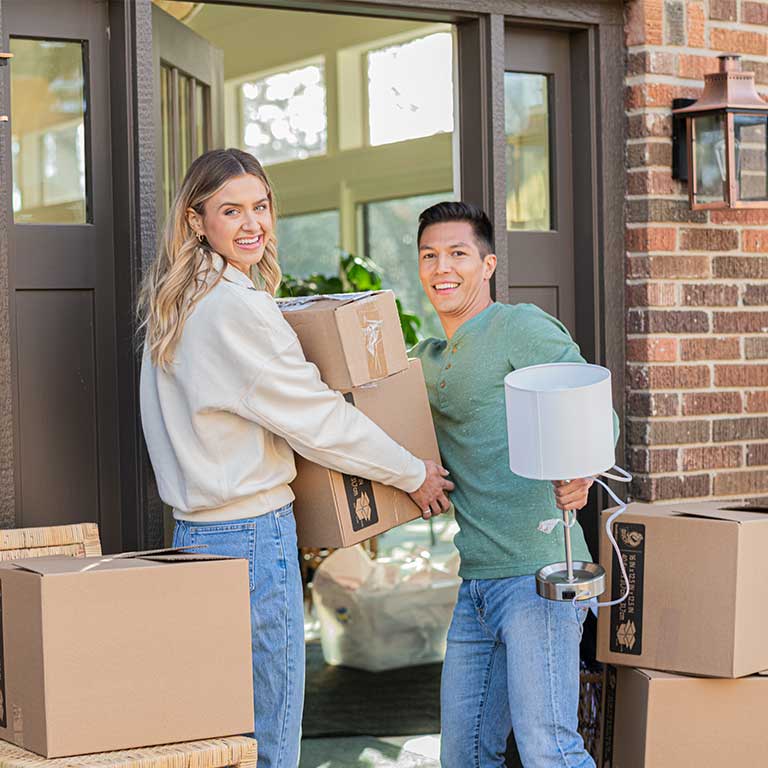 Young man, woman with moving boxes, opening the door to loft