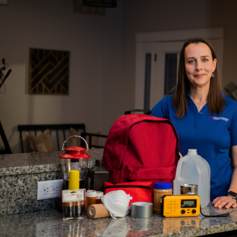 Woman in blue shirt standing next to storm safety kit