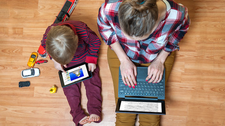 Mom, child sitting on floor on tablet