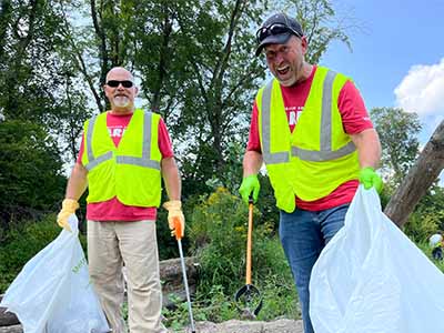 MidAmerican employee volunteers removing trash from a park