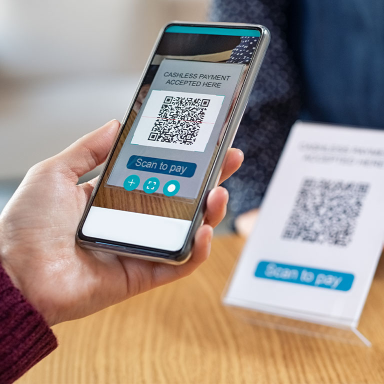 A smartphone scanning a QR code directing the user to a utility payment scam