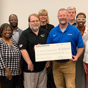 MidAmerican employee presenting a check to a group of Waterloo Career Center representatives.