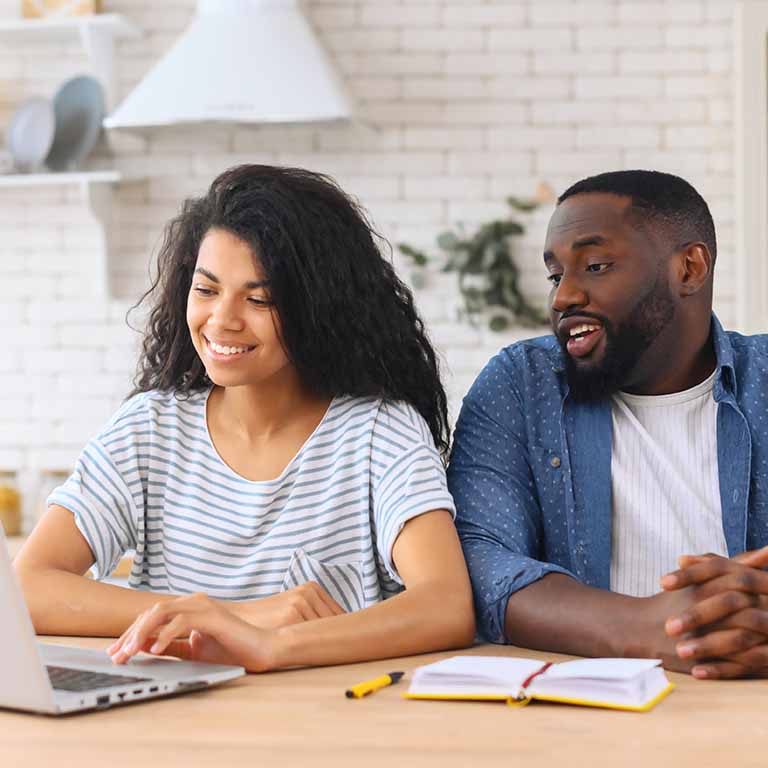 Black couple looking at laptop screen